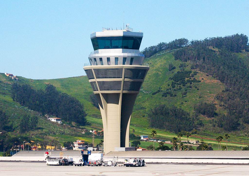 Tenerife North Airport control tower with mountainous terrain in the background, illustrating the airport's elevated location and operational environment.